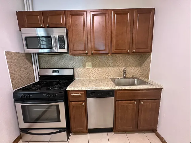 a kitchen with wooden cabinets and a stove top oven