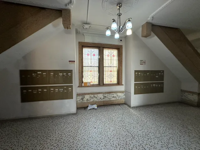 a view of an empty room with a fireplace and a window
