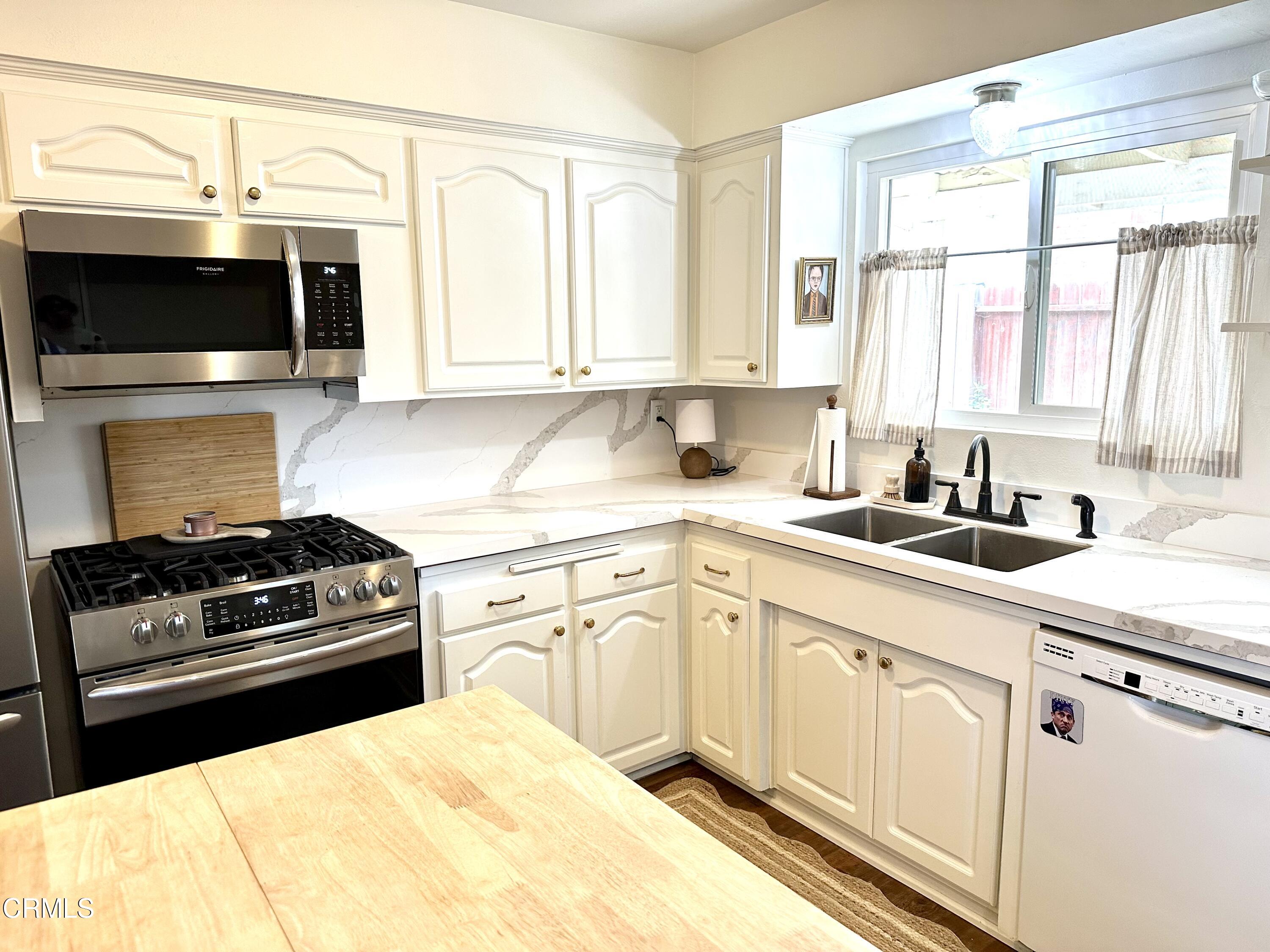 4621 Hamilton Avenue Oxnard, CA 93033 - Photo 4 of 22 a kitchen with stainless steel appliances a sink a stove and a microwave