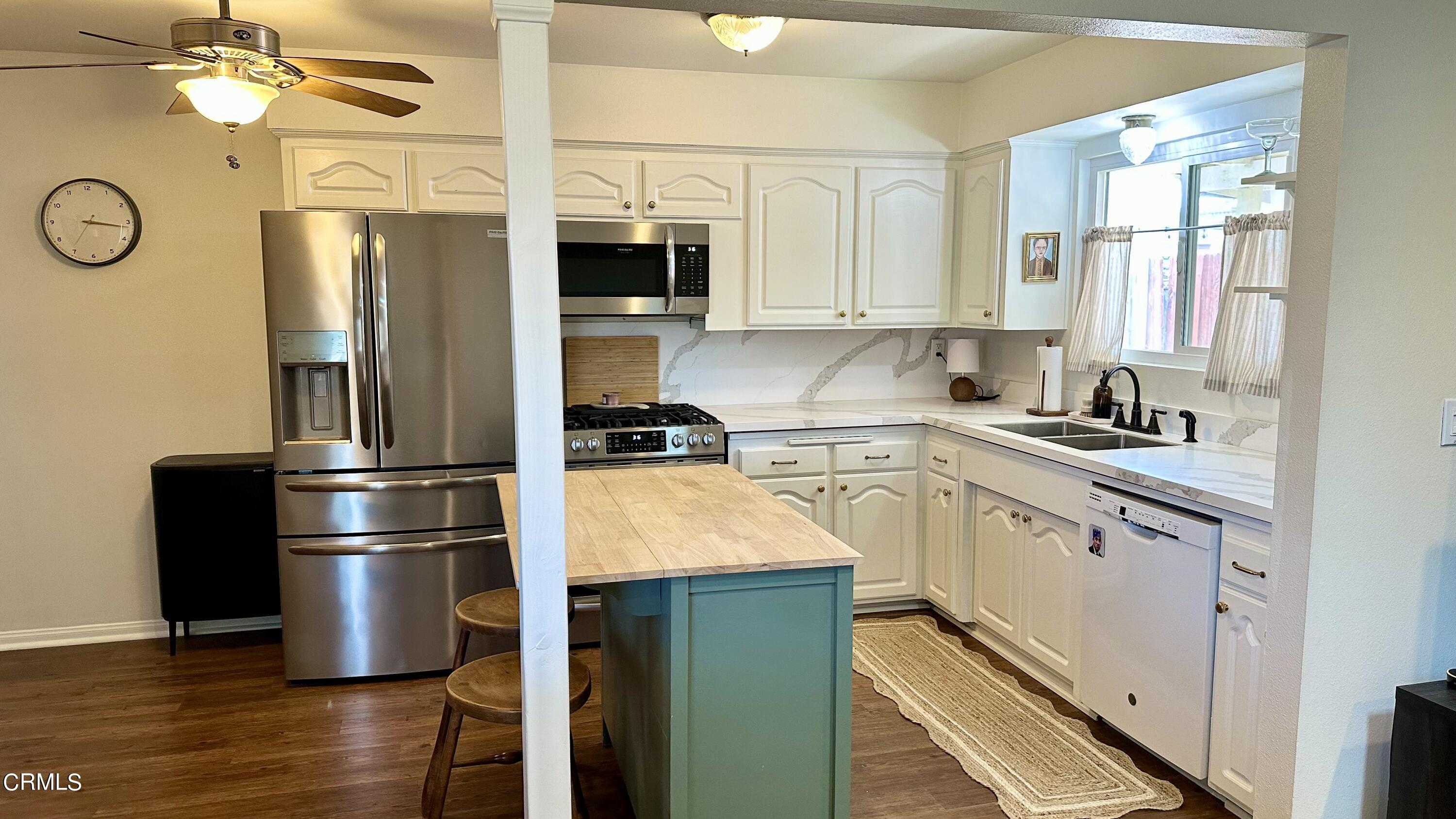 4621 Hamilton Avenue Oxnard, CA 93033 - Photo 5 of 22 a kitchen with stainless steel appliances granite countertop a refrigerator a stove and a sink with wooden floor