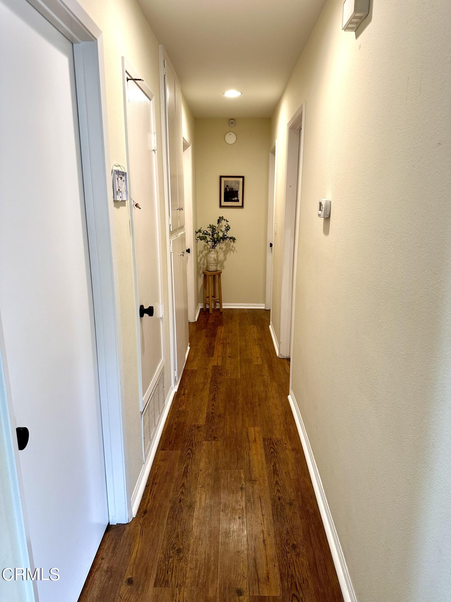 4621 Hamilton Avenue Oxnard, CA 93033 - Photo 9 of 22 a view of a hallway with wooden floor and a bathroom