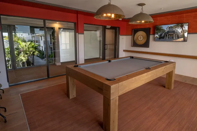 a room with pool table and windows