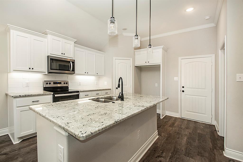 806 Ransom Way Greenville, TX 75402 - Photo 3 of 27 Kitchen featuring white cabinetry, granite countertops, stainless steel appliances, a tile backsplash, and dark wood-finish flooring