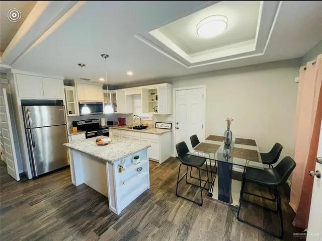 a kitchen with stainless steel appliances granite countertop a white cabinets and wooden floor