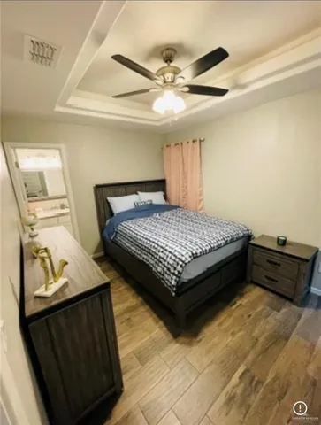 a bedroom with a bed and wooden floor