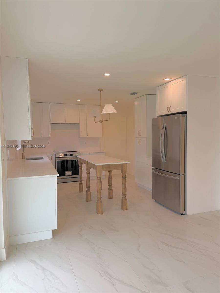 19221 Southwest 92nd Road Cutler Bay, FL 33157 - Photo 8 of 30 a kitchen with stainless steel appliances granite countertop a refrigerator a sink a stove and white cabinets
