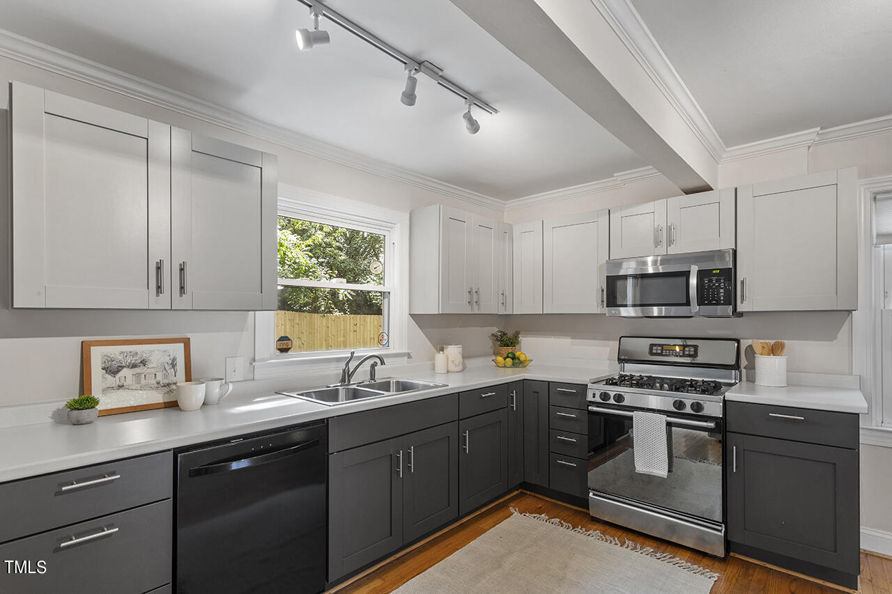 1716 Bennett Street Raleigh, NC 27604 - Photo 6 of 30 a kitchen with stainless steel appliances granite countertop a sink a stove a refrigerator cabinets and a window
