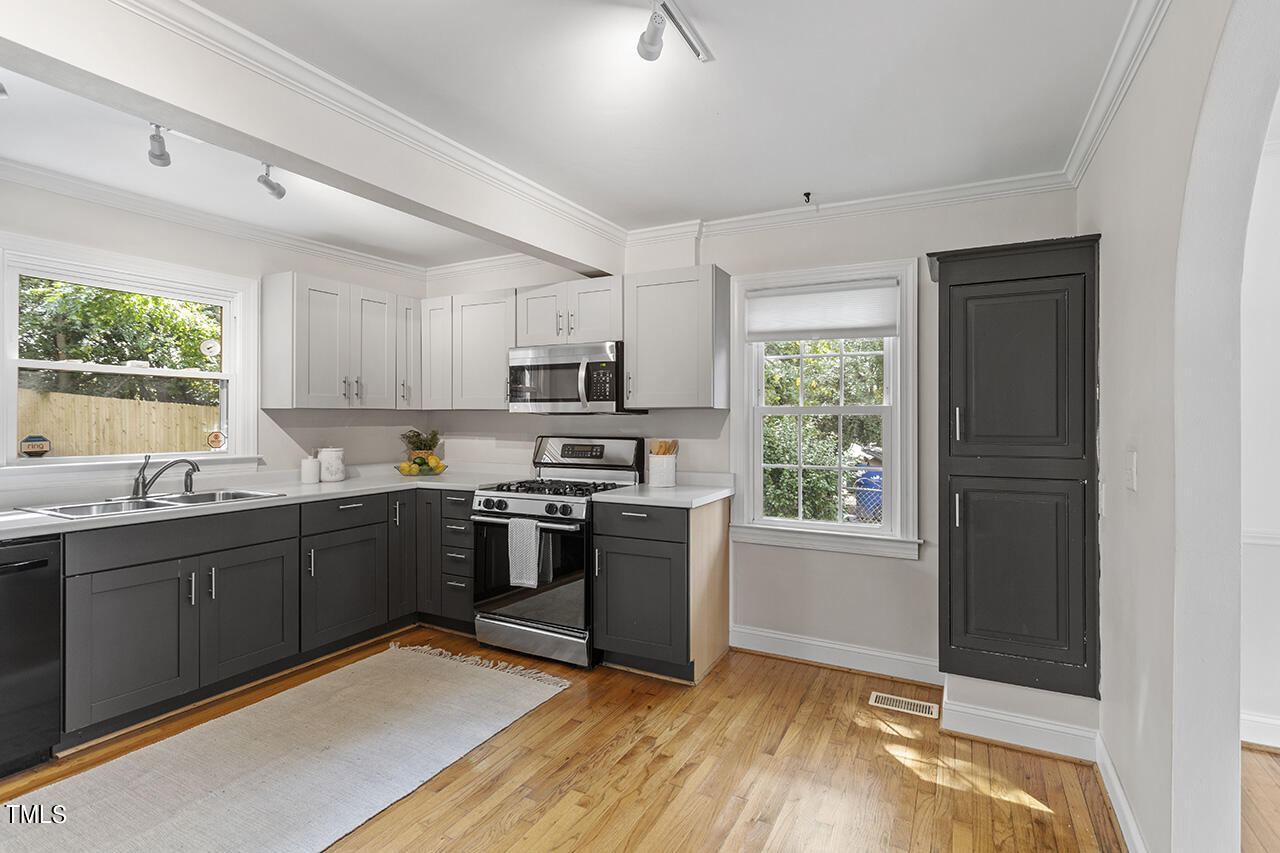 1716 Bennett Street Raleigh, NC 27604 - Photo 8 of 30 a kitchen with stainless steel appliances granite countertop a stove top oven a sink dishwasher a refrigerator and cabinets with wooden floor