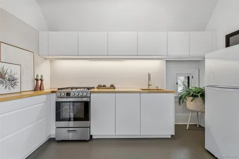 a utility room with cabinets appliances and wooden floor