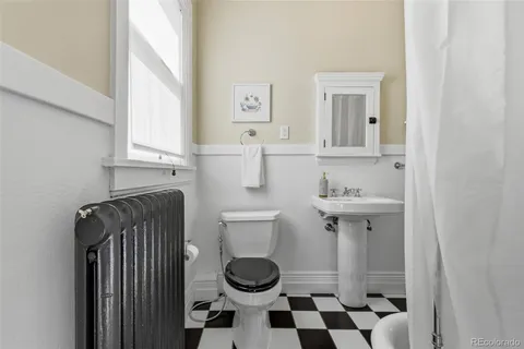 a bathroom with a granite countertop sink and a toilet
