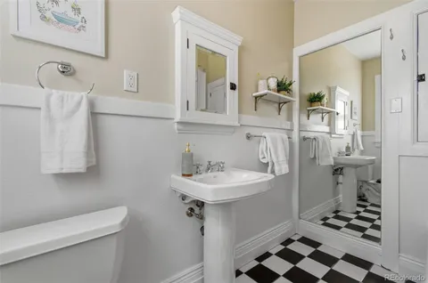 a bathroom with a sink toilet and mirror