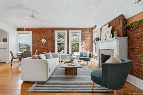 a living room with furniture a large window and a fireplace