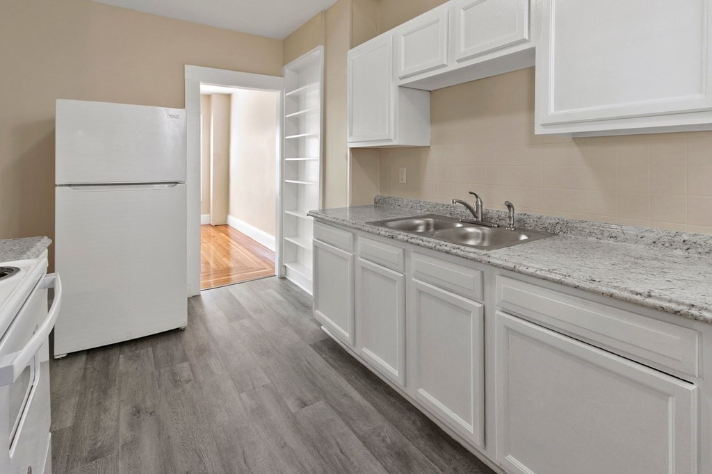 383 White Street Springfield, MA 01108 - Photo 4 of 39 a kitchen with stainless steel appliances granite countertop a refrigerator sink and white cabinets with wooden floor