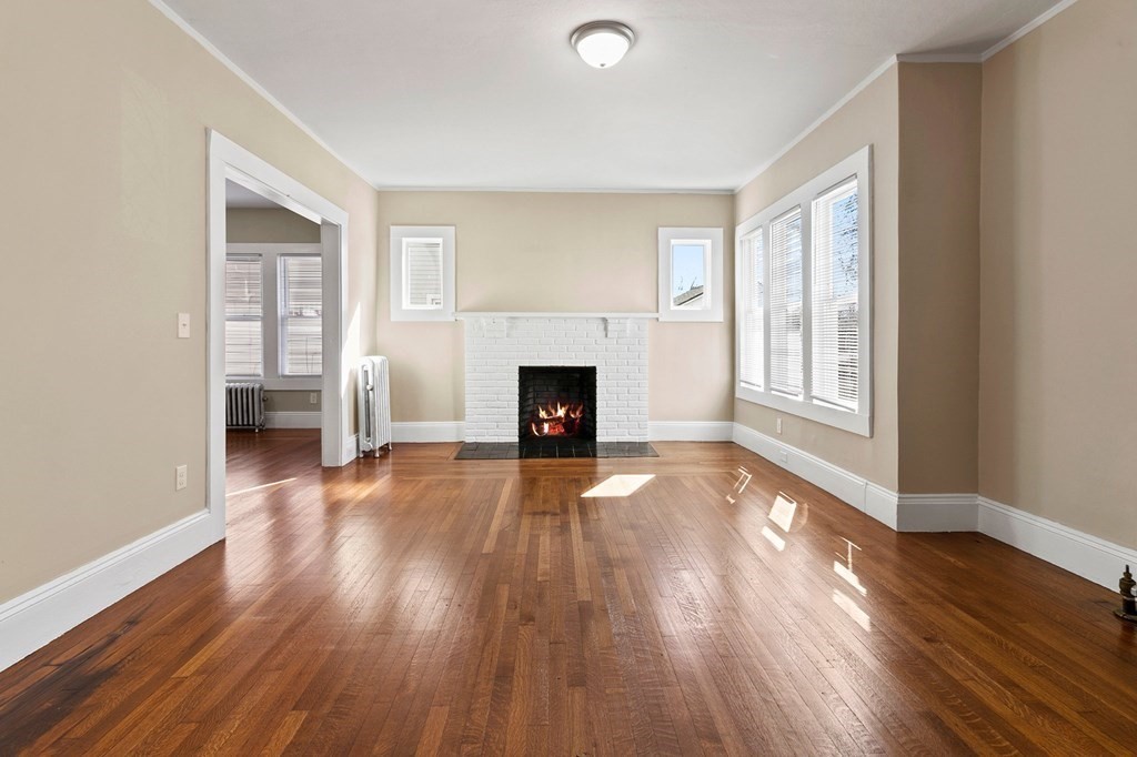 383 White Street Springfield, MA 01108 - Photo 6 of 39 an empty room with wooden floor fireplace and windows
