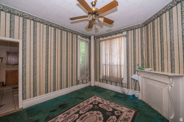 1256 24th Street Ogden, UT 84401 - Photo 7 of 34 Room featuring patterned wallpaper, a ceiling fan with light fixture, and a decorative mantel