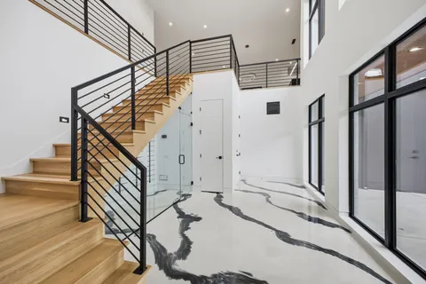 an empty room with wooden floor ceiling fan and windows