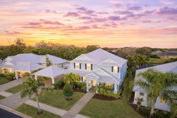 an aerial view of residential houses with outdoor space and trees
