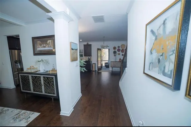 a view of a hallway to a livingroom with furniture and wooden floor