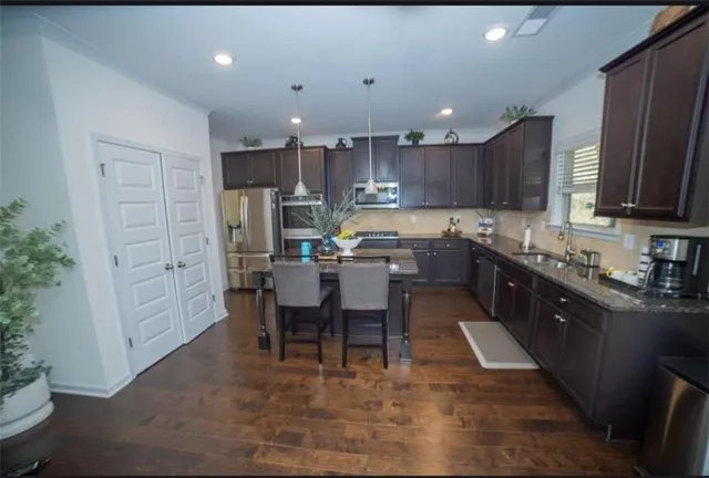 an open kitchen with kitchen island wooden cabinets and stainless steel appliances