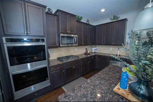 a kitchen with sink a microwave and cabinets