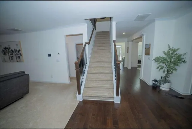 a view of a hallway with wooden floor and stairs