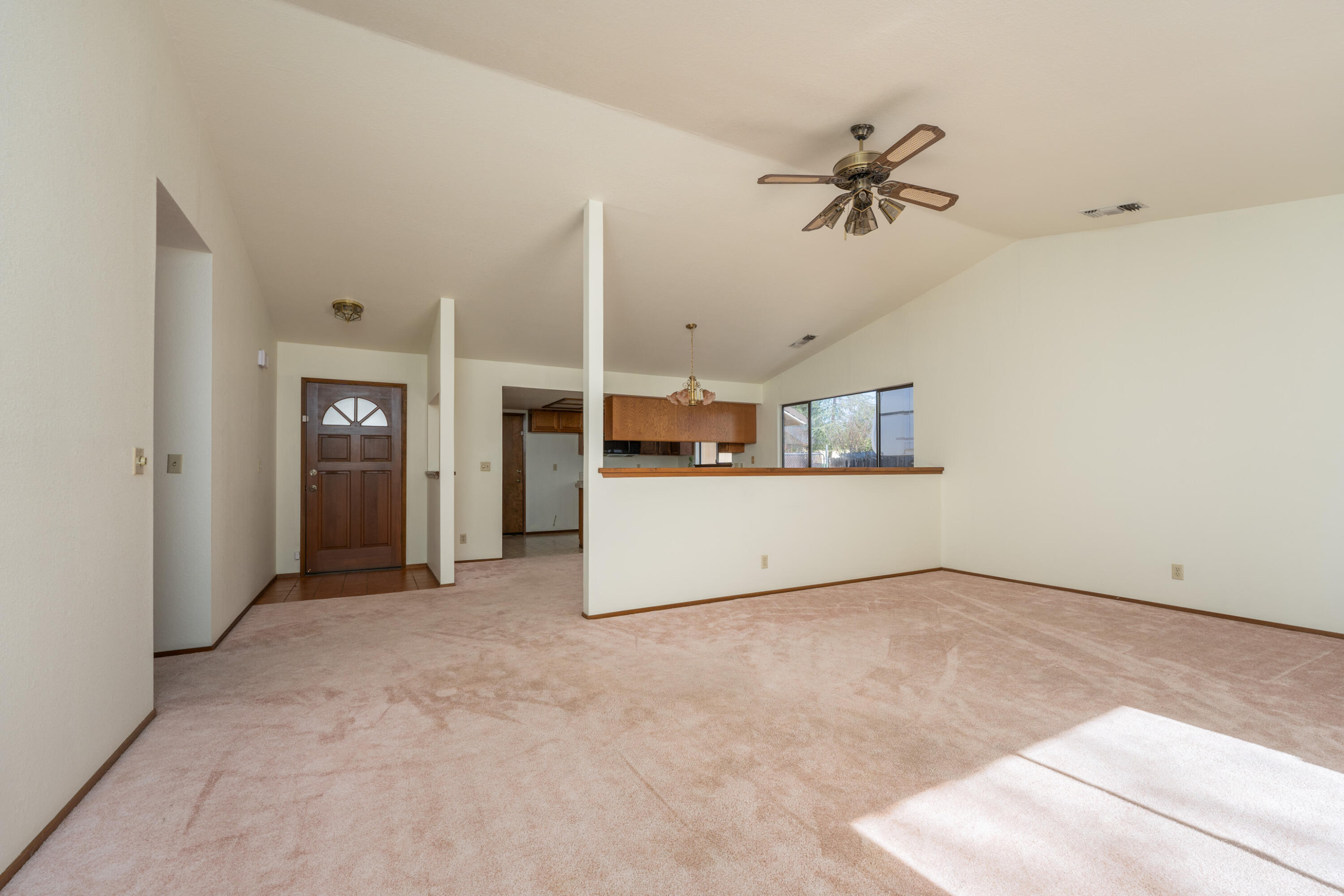 853 Oakmont Drive Redding, CA 96003 - Photo 4 of 37 an empty room with ceiling fan and windows