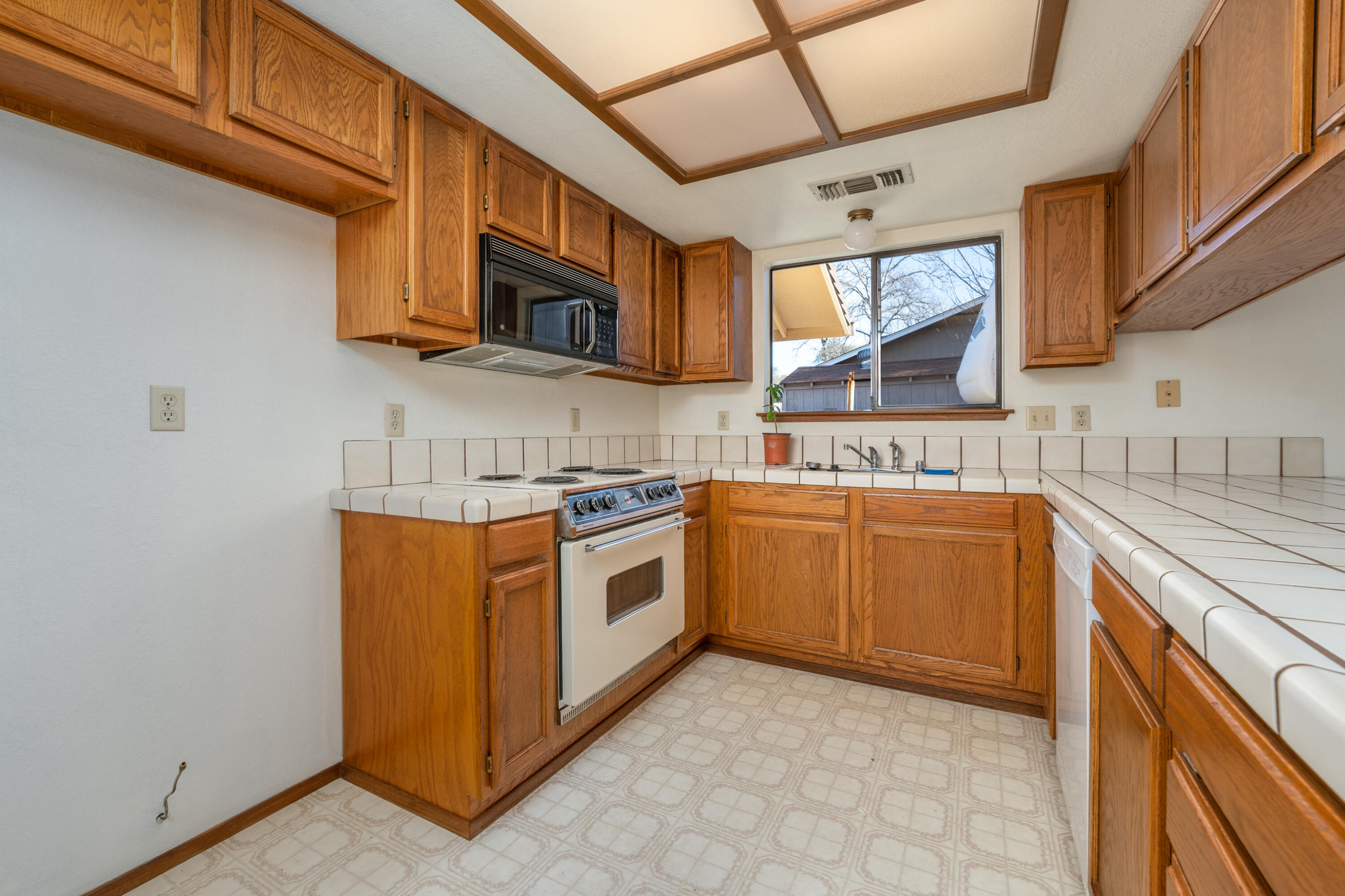 853 Oakmont Drive Redding, CA 96003 - Photo 10 of 37 a kitchen with stainless steel appliances granite countertop a stove top oven a sink dishwasher and white cabinets with wooden floor