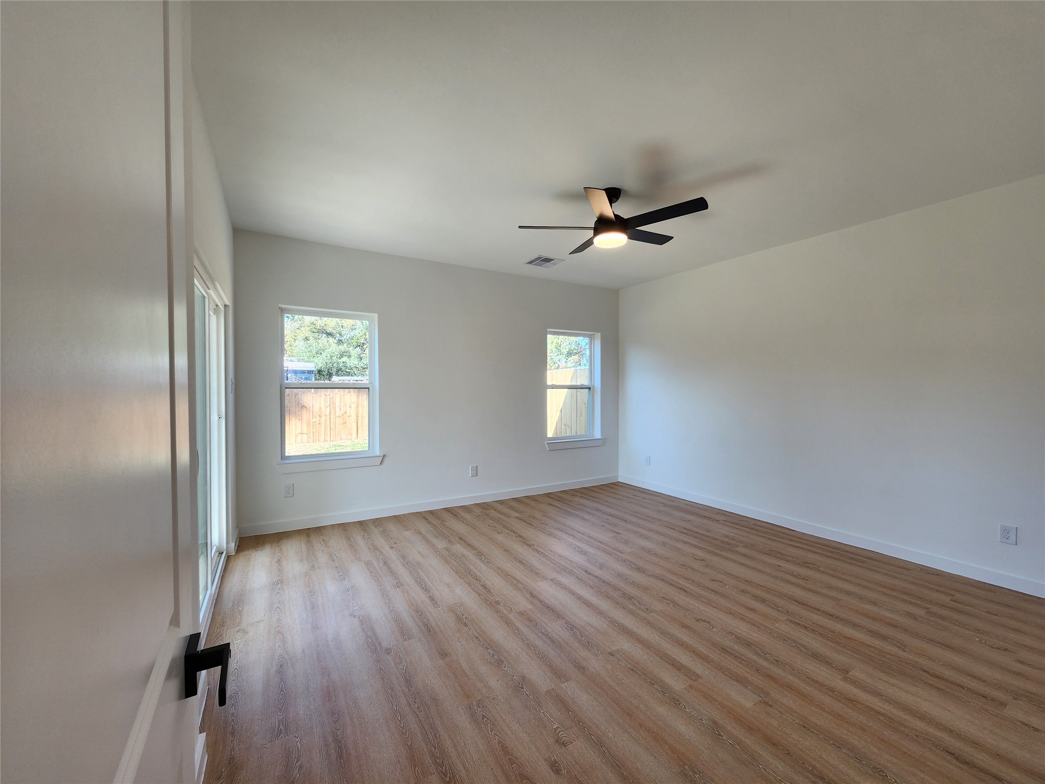 7817 Beckley Street, Unit A Houston, TX 77088 - Photo 8 of 18 wooden floor in an empty room with a window