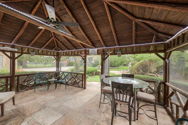 a patio with glass top table and chairs