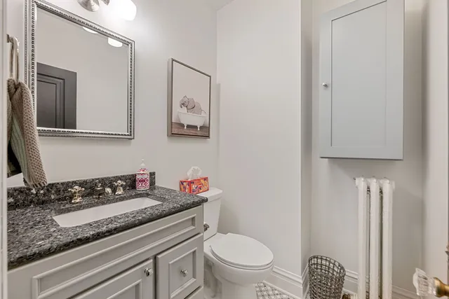 a bathroom with a granite countertop toilet sink and mirror