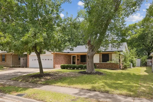 a front view of house with yard and trees