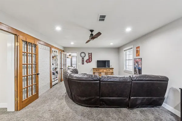 a living room with furniture a flat screen tv and a window