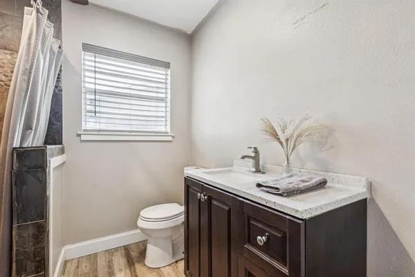a bathroom with a granite countertop sink toilet and mirror