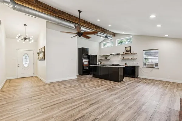 a view of kitchen with stainless steel appliances granite countertop a sink and cabinets