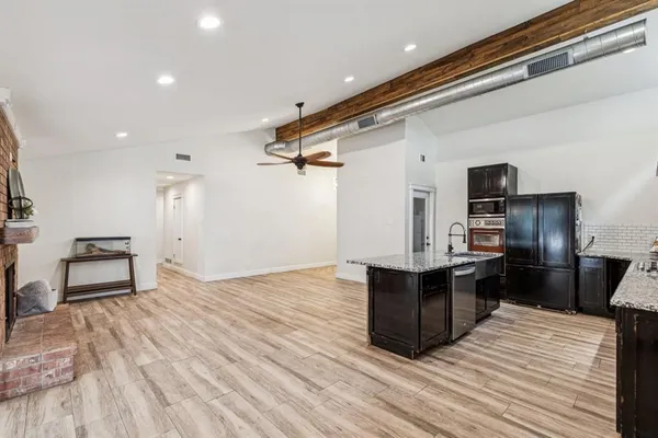 a kitchen with stainless steel appliances kitchen island granite countertop a refrigerator and a stove top oven