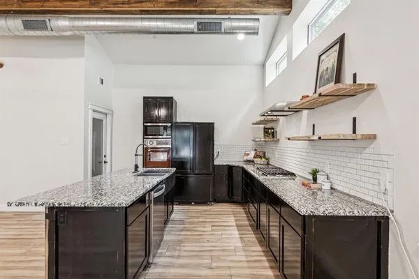 a kitchen with stainless steel appliances granite countertop a sink stove and refrigerator