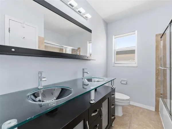 a bathroom with a sink a toilet and a mirror