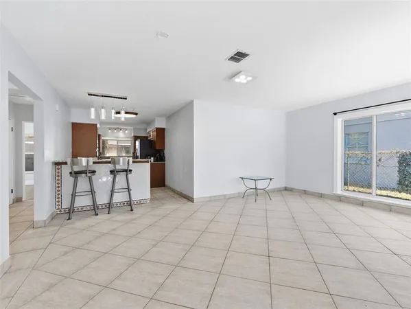 a living room with furniture and a dining table with kitchen view