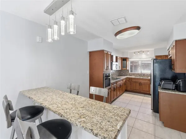 a kitchen with stainless steel appliances kitchen island granite countertop a sink and cabinets