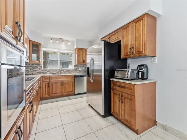 a kitchen with stainless steel appliances granite countertop a stove a sink dishwasher and a refrigerator