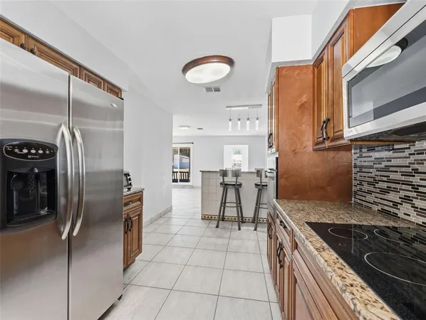 a kitchen with stainless steel appliances granite countertop a stove a refrigerator and a sink