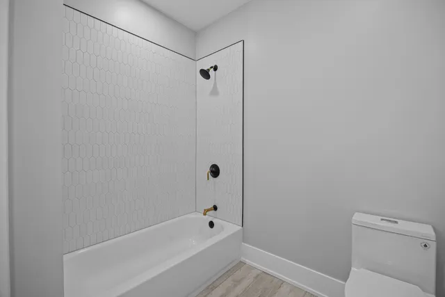 wooden floor in an empty room with a bathroom