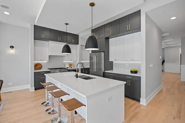 a kitchen with stainless steel appliances granite countertop a sink a stove and a refrigerator