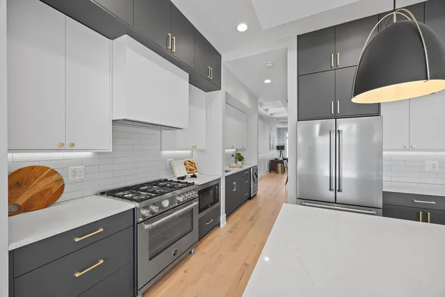 a kitchen with stainless steel appliances granite countertop a sink a stove and a refrigerator