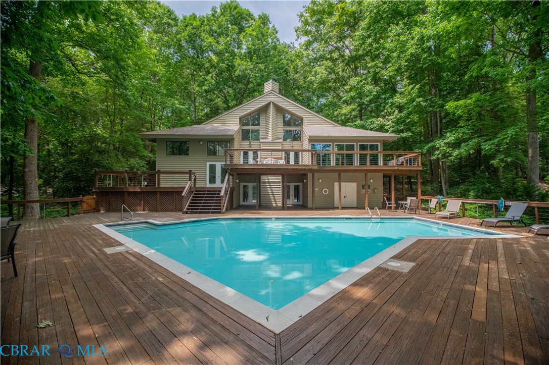 54 Villa Ridge Drive, Unit C Hartfield, VA 23071 - Photo 27 of 45 Swimming pool featuring a wooden deck, view of scattered trees, and a patio area