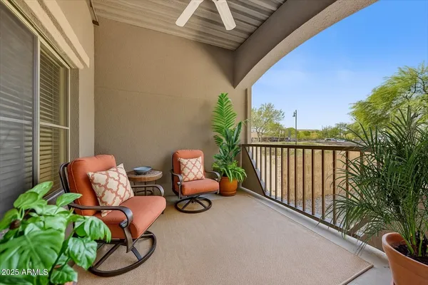 a balcony with couple of chairs and a couch