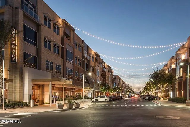 a city street lined with parked cars and palm trees