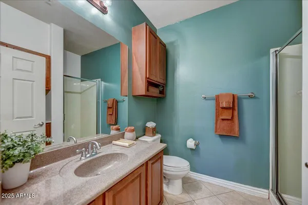 a bathroom with a granite countertop sink toilet and mirror
