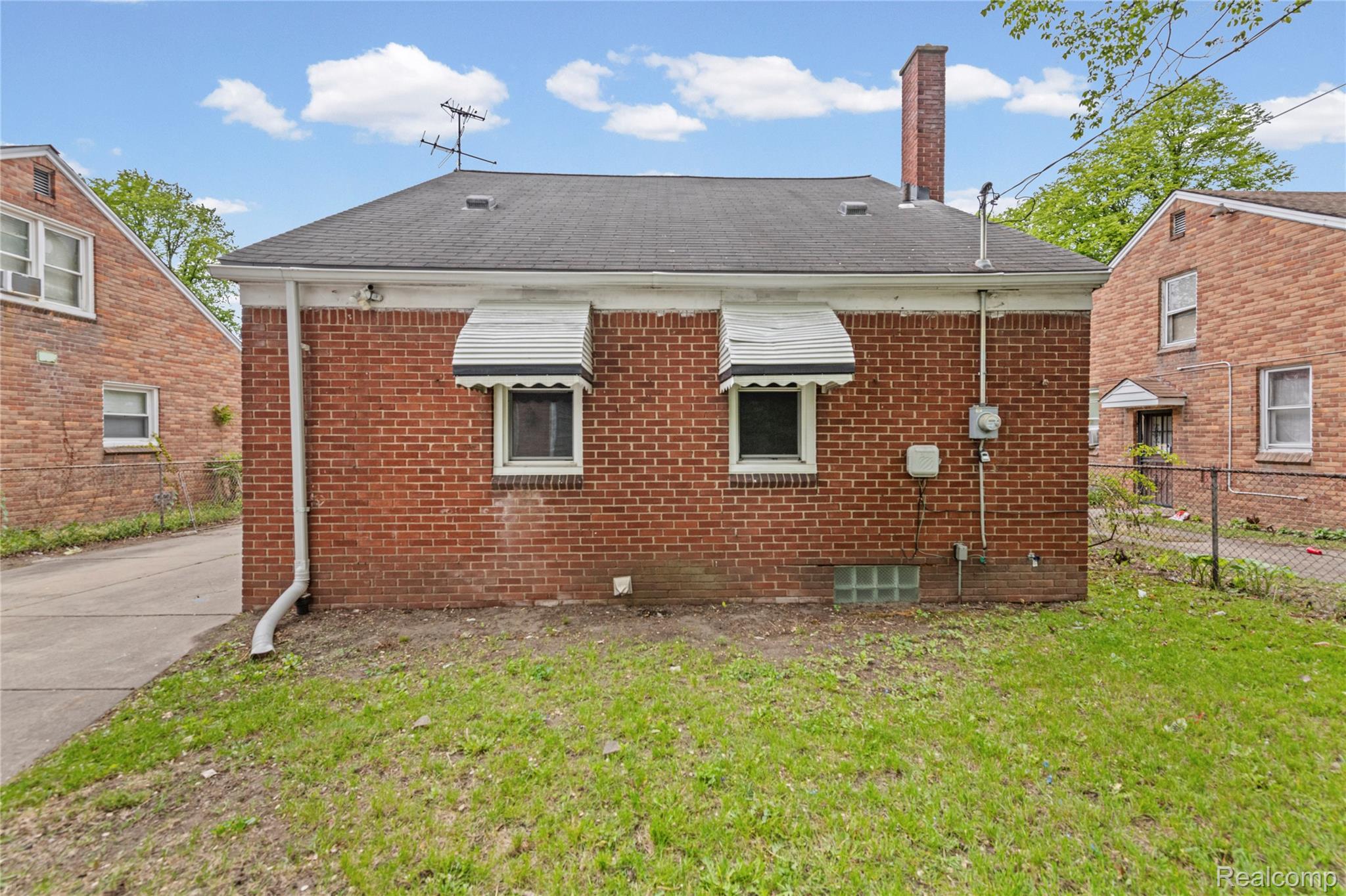 Back of property with a chimney and brick siding