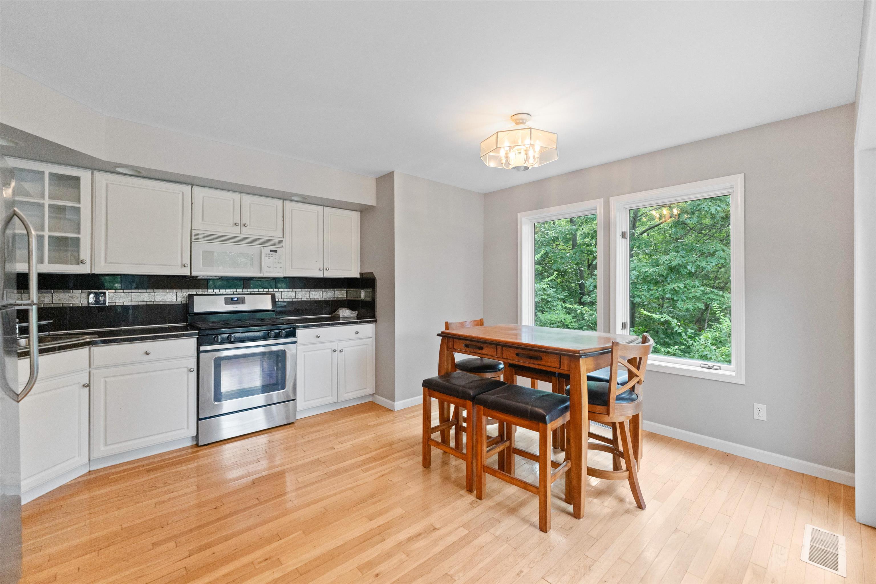 703 Rock Court Dixon, IL 61021 - Photo 12 of 42 a kitchen with stainless steel appliances granite countertop a stove top oven a sink with a dining table and chairs